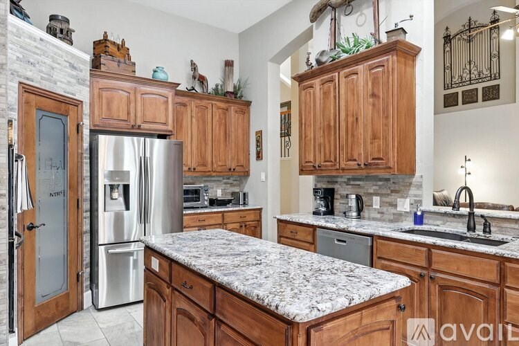 A kitchen with wooden cabinets and granite countertops.