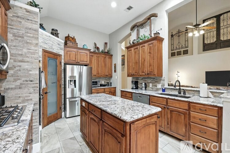 A kitchen with wooden cabinets and granite countertops.
