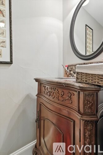 A brown antique style chest of drawers with a mirror above it.