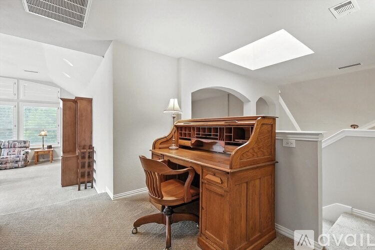 A room with a wooden desk and a chair.