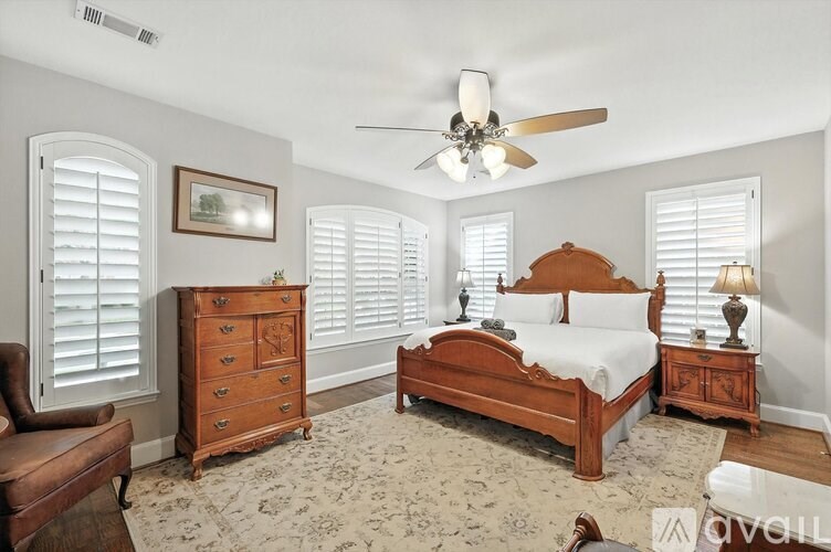 A bedroom with a bed, dresser, and chair.