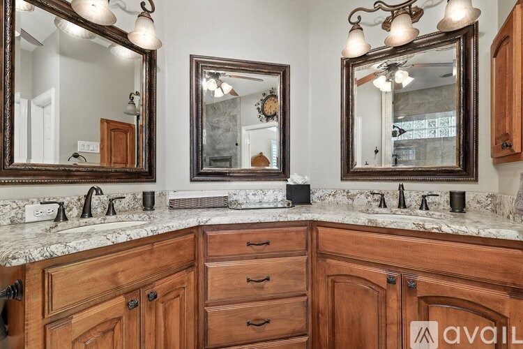 A bathroom with two mirrors and wooden cabinets.