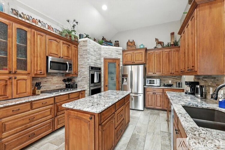 A kitchen with wooden cabinets and a marble countertop.