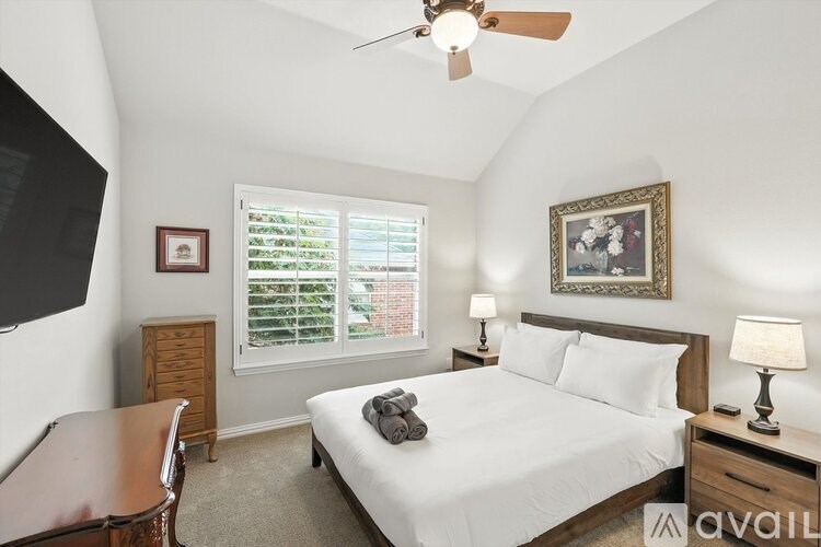 A bedroom with a bed, nightstand, and a ceiling fan.