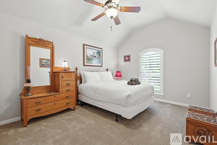 A bedroom with a bed, dresser, and mirror.