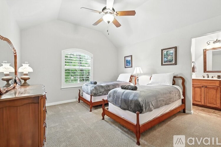 A bedroom with two beds and a ceiling fan.