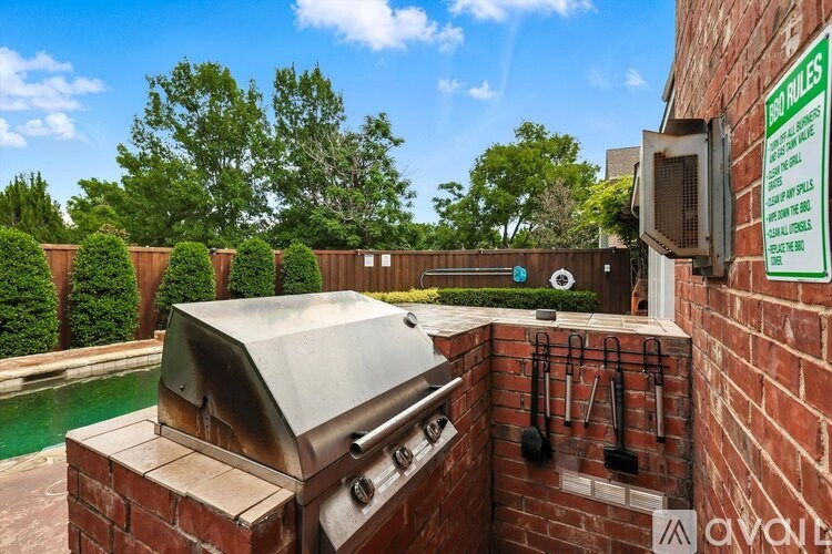 A brick wall with a grill on top and a sign on the right side.