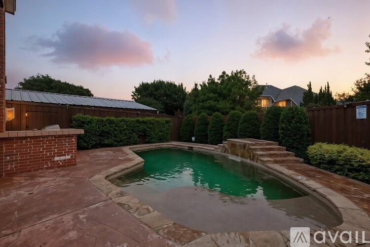 A backyard with a pool and a house in the background.