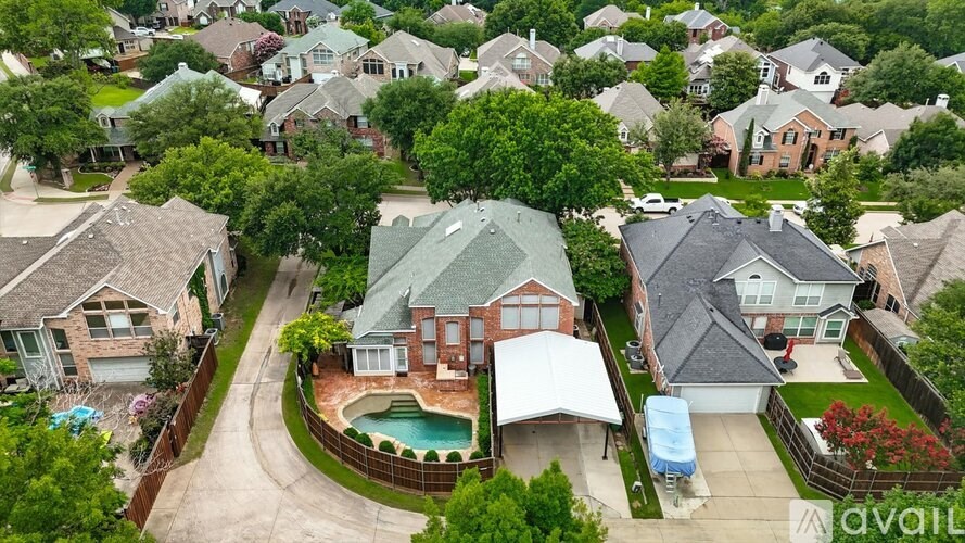 A bird's eye view of a residential area with houses and a pool.