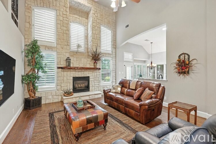 A living room with a brown leather couch and a wooden coffee table.