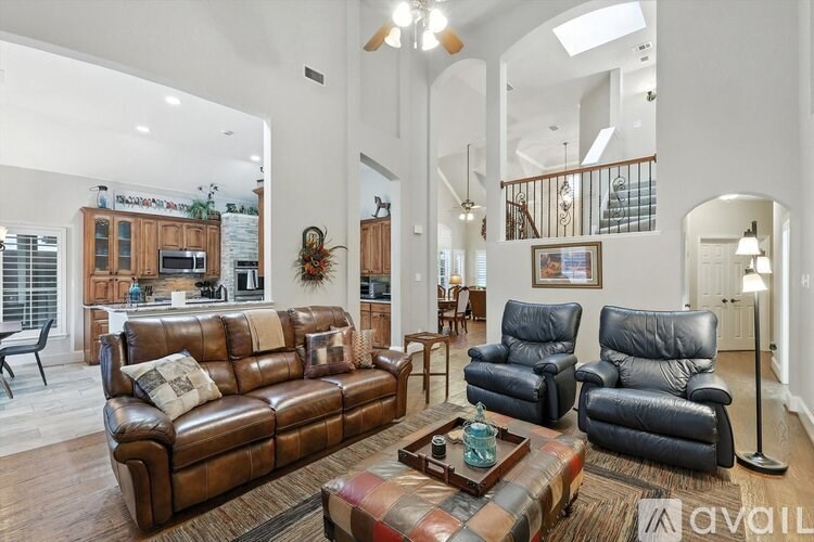 A living room with a brown leather couch and a coffee table.