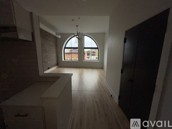 A room with a large window and wooden flooring.