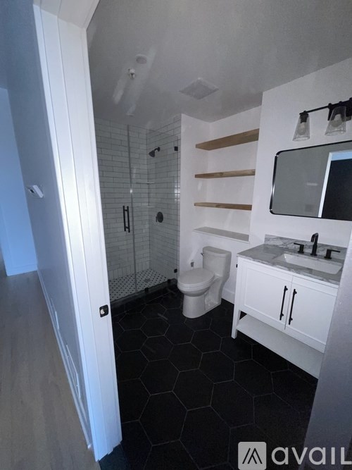 A bathroom with a toilet, sink, and mirror.