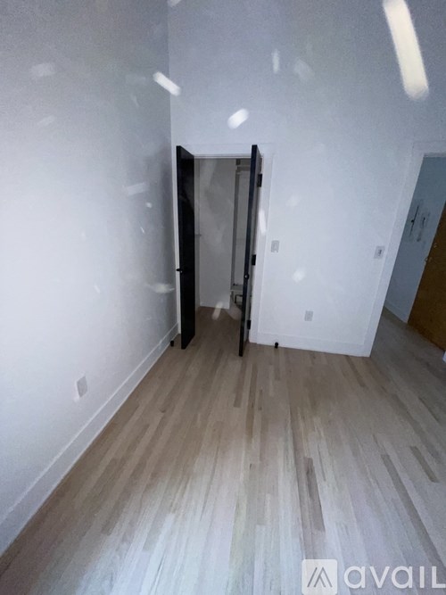 A room with a sliding door and wooden flooring.