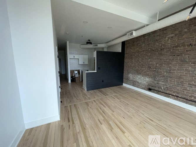 A room with wooden floors and a brick wall.