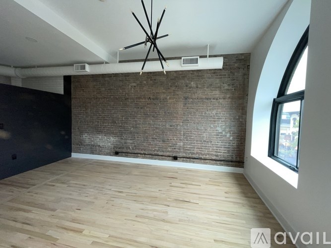 A room with wooden floors and a brick wall.