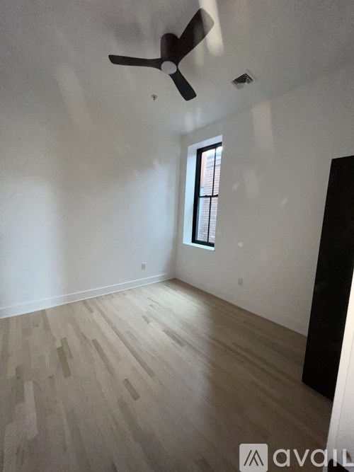 A room with a ceiling fan and a window.
