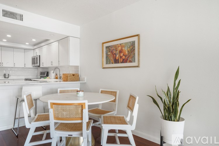 A white dining room with a round table and chairs.