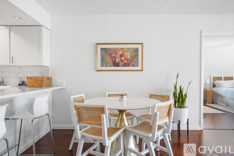 A dining room with a white table and chairs.