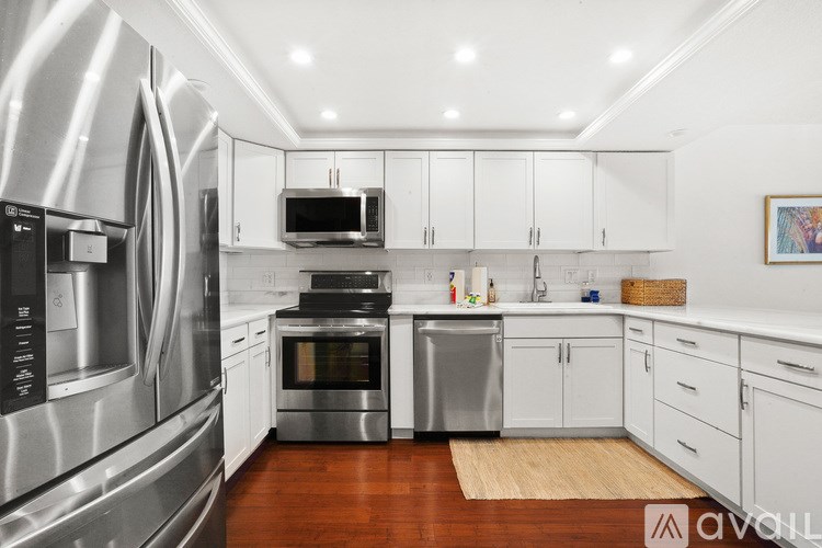 A modern kitchen with stainless steel appliances and white cabinets.