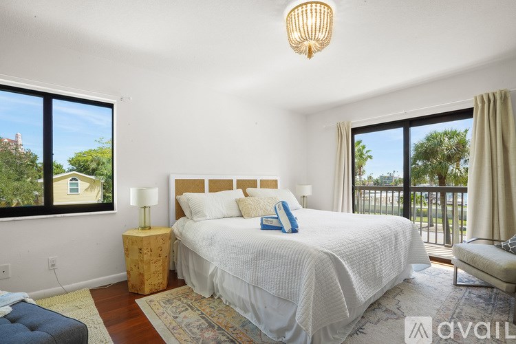 A bedroom with a large bed and a view of the outdoors through the window.