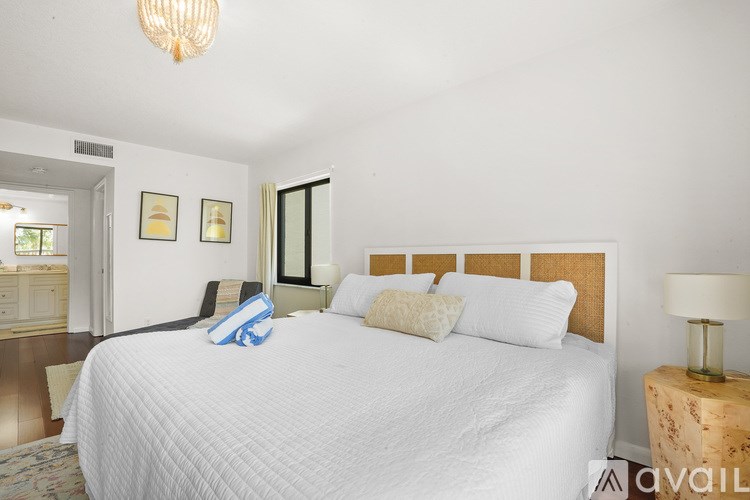 A bedroom with a large bed and a chandelier.