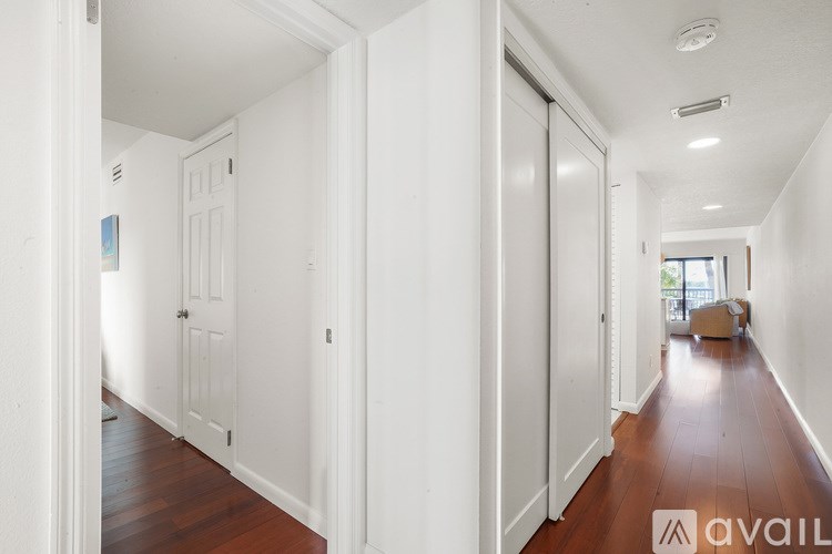 A long hallway with white walls and wood floors.