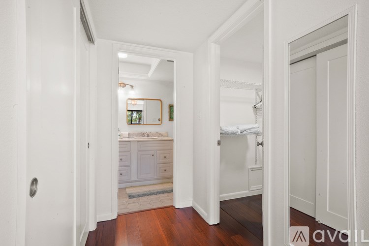 A hallway with a mirror and a white door.