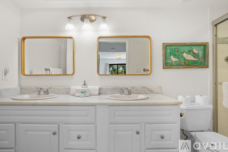 A bathroom with two sinks and two mirrors.