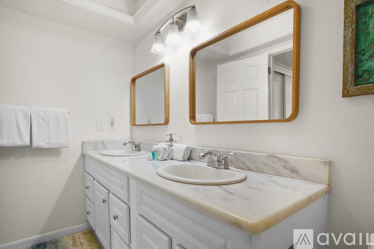 A bathroom with a marble countertop and two sinks.