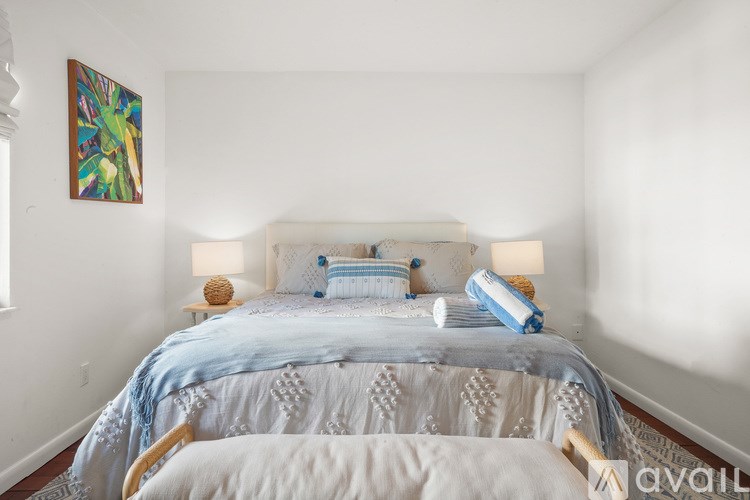 A bedroom with a bed and a painting on the wall.