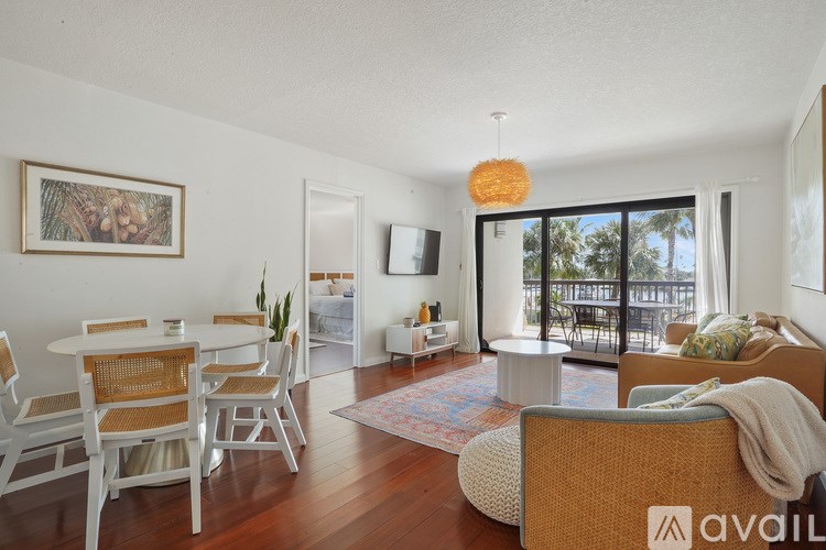 A living room with a couch, chairs, and a painting on the wall.