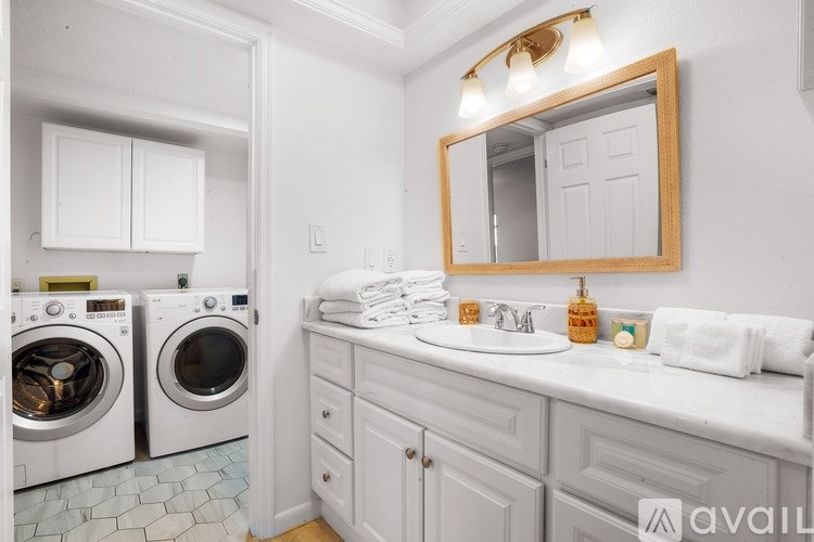 A bathroom with a washer and dryer built into the cabinetry.
