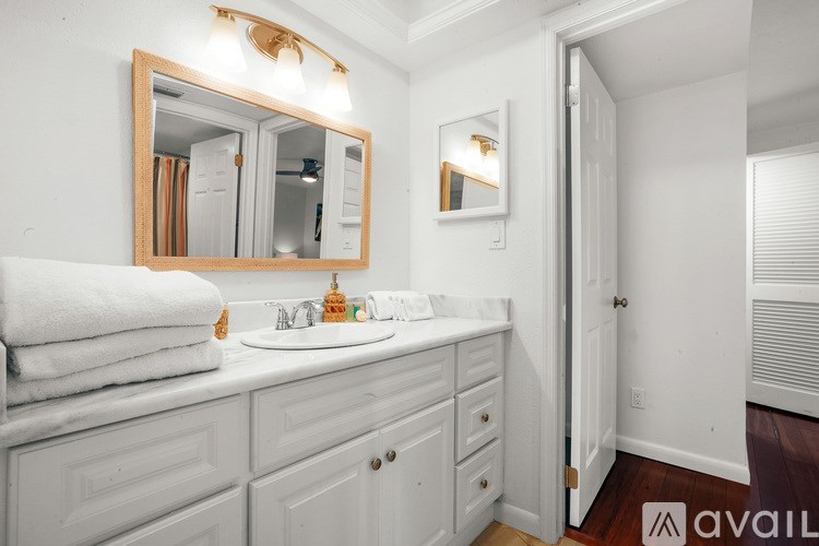 A bathroom with a white sink and a mirror above it.