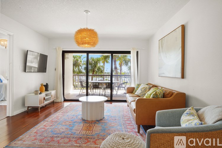 A living room with a white couch and a television on the wall.