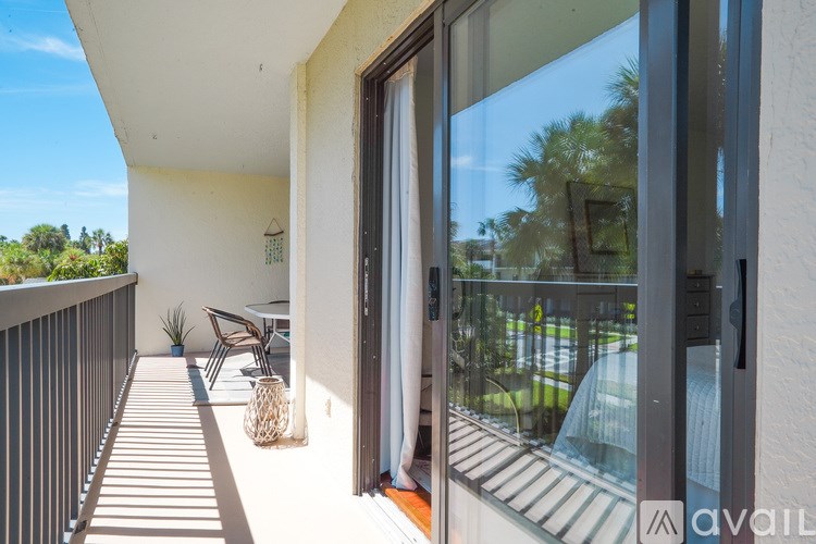 A balcony with a chair and a table is shown.