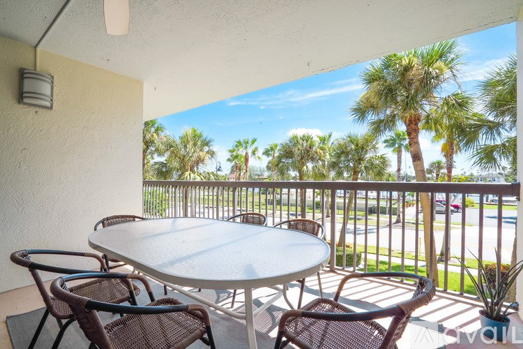 A patio with a table and chairs overlooking a street.