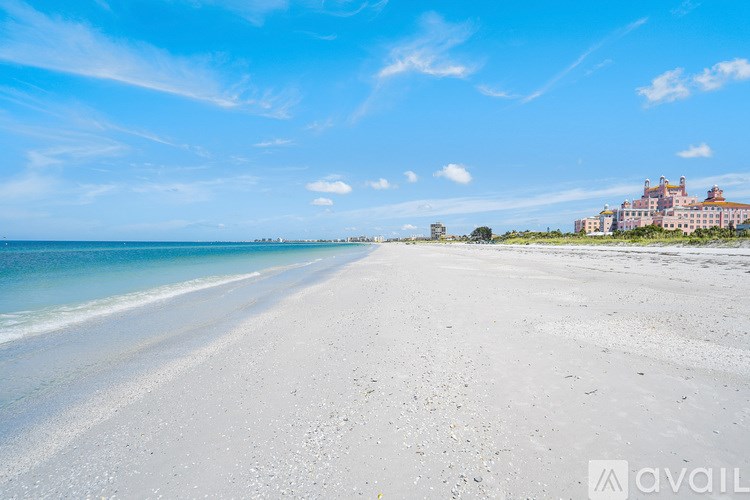 A beach with a clear sky and a building in the distance.