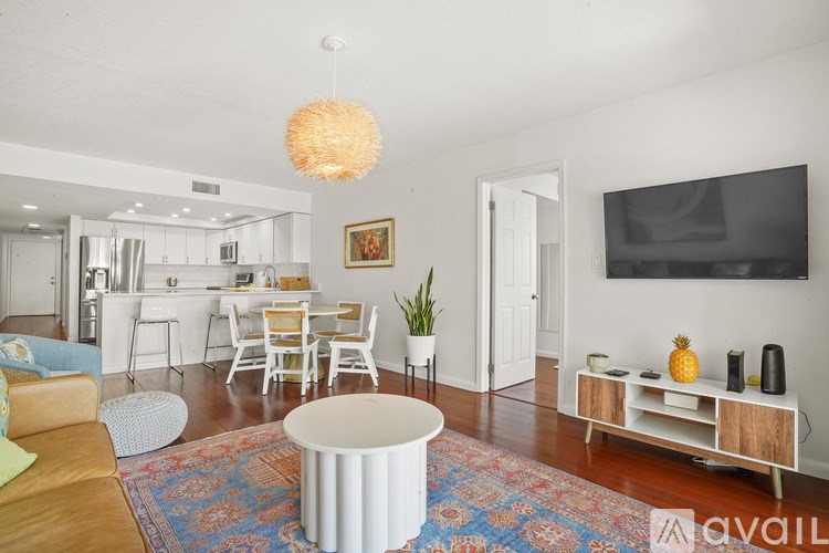A living room with a white sofa, a white coffee table, and a white cabinet.