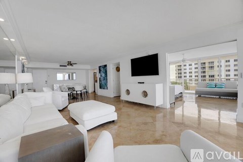 A living room with white furniture and a flat screen TV.