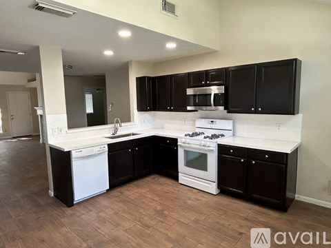A kitchen with black cabinets and white countertops.