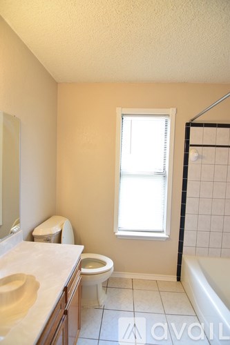 A bathroom with a white tub and a shower curtain with a floral pattern.