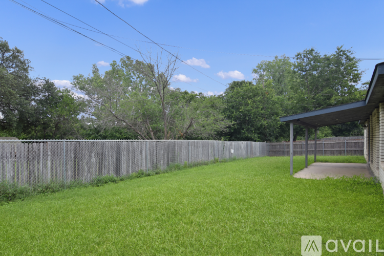 A house with a fence and green grass in front.