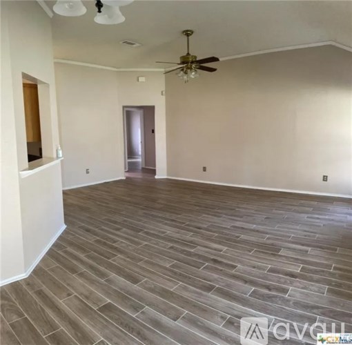 A room with wooden flooring and a ceiling fan.