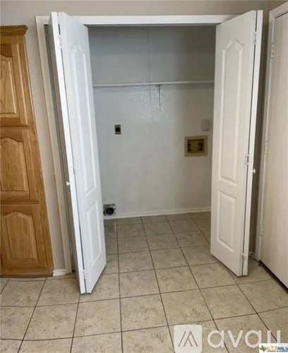 A white door is open to a room with a tiled floor.