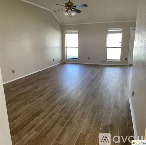 A room with wooden flooring and a ceiling fan.