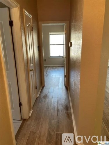 A hallway with wooden floors and white doors.