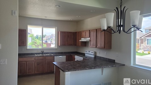 A kitchen with brown cabinets and a granite countertop.
