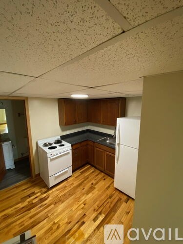 A kitchen with wooden floors and white appliances.