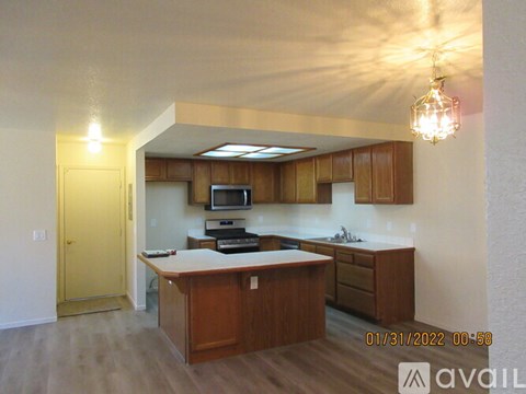 A kitchen with wooden cabinets and a countertop with a microwave and oven.